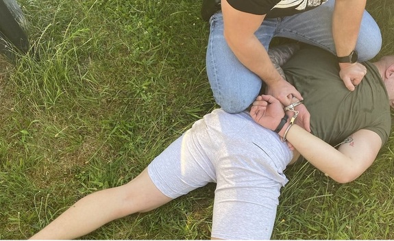 zatrzymany  na ziemi  jest przytrzymany przez policjanta