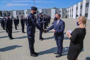 14. Wojewoda Małopolski wręczający kodeksy honorowe ślubującym policjantom