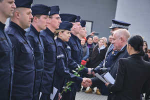 Komendant Wojewódzki Policji w Krakowie oraz pierwszy wice Wojewoda małopolski wręczają nowym policjantom legitymacje służbowe oraz zasady etyki zawodowej