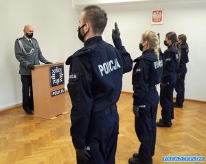 nowi policjanci ślubują mając podniesione ręce do góry