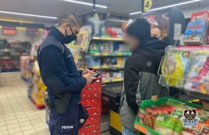 policjant kontroluje mężczyznę w sklepie