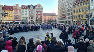 widok nieco z góry na ludzi zgromadzonych na rynku we Wrocławiu, na wprost orkiestra policyjna