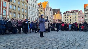 zgromadzeni ludzie na rynku wrocławskim wokół dyrygenta orkiestry policyjnej