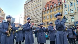 orkiestra wchodząca na rynek prowadzona przez policjanta z batutą