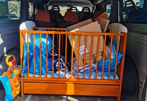 Samochód, w którym znajduje się łóżeczko dziecięce i zabawki dla dzieci z Ukrainy