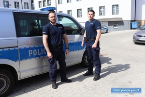 policjanci stojacy koło radiowozu