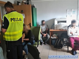 zatrzymani imigranci i policjant