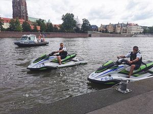 umundurowani policjanci na dwóch skuterach wodnych oraz łódka policyjna