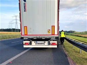 Policjant przechodzący obok pojazdu ciężarowego