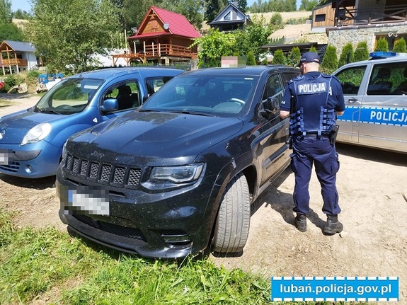 Policjant stojący przy odzyskanym pojeździe