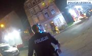 Policjant stoi przed budynkiem