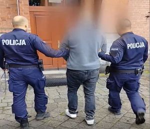 Policjanci prowadzą zatrzymanego