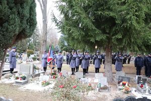 policjanci w mundurach galowych stoją przy sztandarze