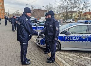 Nadinspektor Dariusz Wesołowski gratuluje policjantowi przekazanego nowego radiowozu.
