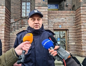 Na zdjęciu policjant udziela wywiadu dziennikarzom.