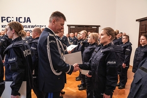 Komendant Wojewódzki policji wrecza akty ślubowania nowym policjantom