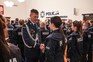 Komendant Wojewódzki policji wrecza akty ślubowania nowym policjantom