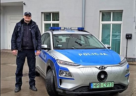 Policjant przy radiowozie.