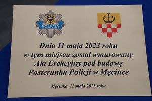 Na zdjęciu tablica z napisem: dnia 11 maja 2023 roku w tym dniu został wmurowany Akt Erekcyjny pod budowę Posterunku Policji w Męcince.