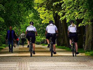 Na zdjęciu dwie policjantki i policjant jadący na rowerach (zdjęcie z tyłu).
