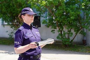 Policjantka trzyma pamiątkową tubę - kapsułę czasu.