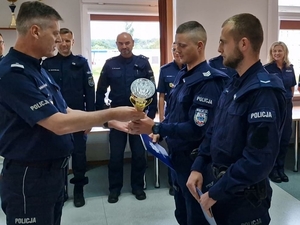 Komendant Wojewódzki Policji we Wrocławiu nadinspektor Dariusz Wesołowski wręcza puchar policjantom.