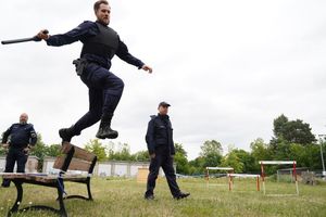 Policjant przeskakuje przez ławkę.