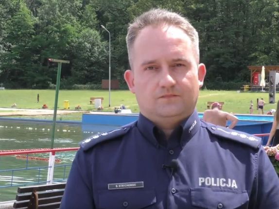 policjant w mundurze stojący na tle wody