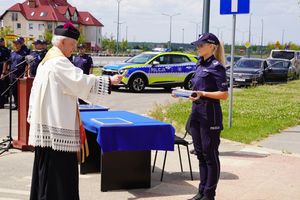 Ksiądz kanonik Marek Pluskota – Dziekan Dekanatu Polkowickiego święci tubę, którą trzyma policjantka.