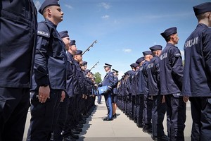 Komendant Wojewódzki Policji we Wrocławiu nadinspektor Dariusz Wesołowski składa gratulacje poszczególnym nowo przyjętym policjantom stojącym w dwuszeregu.