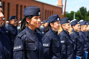 Uśmiechające się nowo przyjęte policjantki, stojące w pierwszym szeregu.