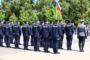 Nowo przyjęci policjanci stojący podczas uroczystego apelu - zdjęcie z tyłu.
