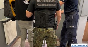 Policjanci prowadzą zatrzymanych mężczyzn