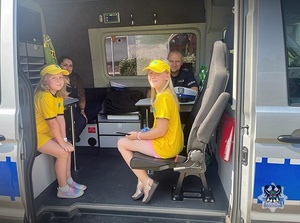 Dwie dziewczynki siedzące w policyjnym busie.