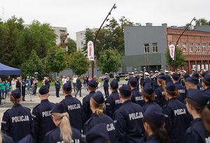 Nowoprzyjęci policjanci obserwują koncert orkiestry policyjnej.