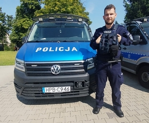 Policjant stojący przy radiowozie