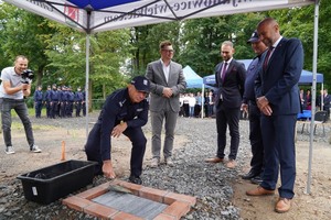 I Zastępca Komendanta Wojewódzkiego Policji inspektor Robert Frąckowiak wmurowuje akt erekcyjny. Obok stoją zaproszeni oficjele.