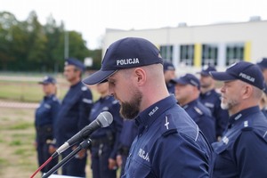 Przemawia policjant prowadzący spotkanie. w tle policjanci.