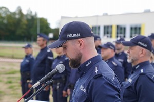 Przemawia policjant prowadzący spotkanie. w tle policjanci.