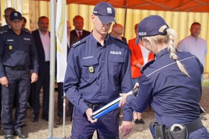 Policjantka wkłada dokument aktu erekcyjnego w tubę.