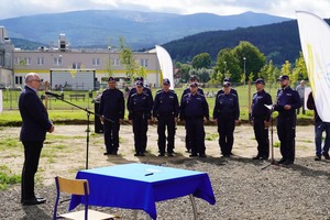 Przemówienie mężczyzny, w tle policjanci stojący w szeregu i góry.