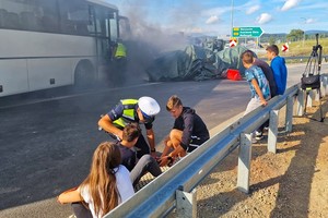 Policjant udziela pomocy poszkodowanym osobom -  sceny z ćwiczenia służb ratowniczych na drodze S-3 z udziałem dolnośląskich policjantów.