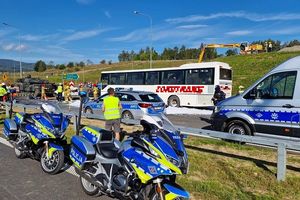 Na pierwszym planie policyjne motory i radiowozy w tle sceny z wypadku - sceny z ćwiczenia służb ratowniczych na drodze S-3 z udziałem dolnośląskich policjantów.