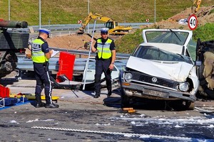 Dwaj policjanci robią oględziny z miejsca wypadku - sceny z ćwiczenia służb ratowniczych na drodze S-3 z udziałem dolnośląskich policjantów.