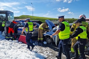 Policjanci i strażacy poruszają się między czterema samochodami uczestniczącymi w wypadku - sceny z ćwiczenia służb ratowniczych na drodze S-3 z udziałem dolnośląskich policjantów.