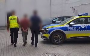 Dwóch policjantów prowadzi mężczyznę do radiowozu