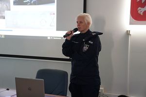 policjantka z mikrofonem w ręku w pomieszczeniu
