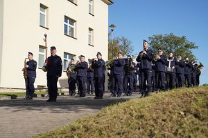 stojący na wzniesieniu policjanci z instrumentami muzycznymi