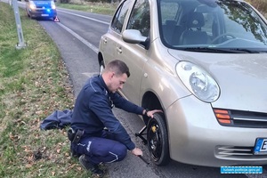 policjanci wymieniają koło w samochodzie