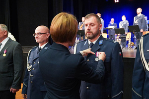 Przedstawicielka Wojewody dolnośląskiego przypina odznakę policjantowi.